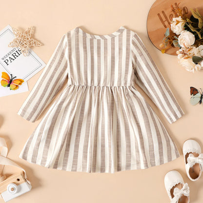 Full length image of a baby girl's long sleeve ribbed striped dress, showcasing its flowy skirt