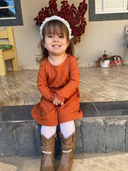 Front view of a baby girl's long sleeve striped ribbed dress, showcasing its charming design