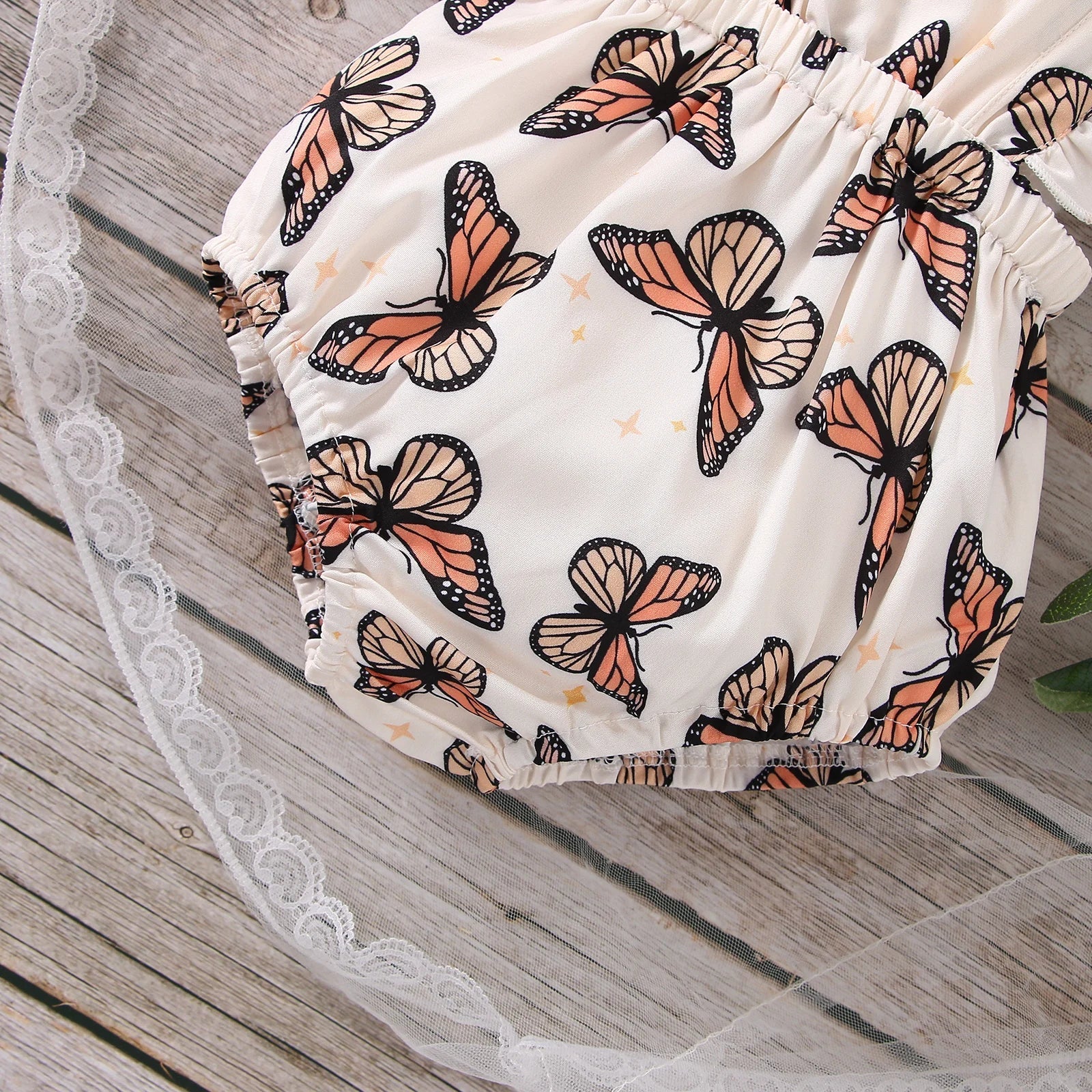 Adorable baby girl's polyester bodysuit with all-over butterfly print and sleeveless ruffle design