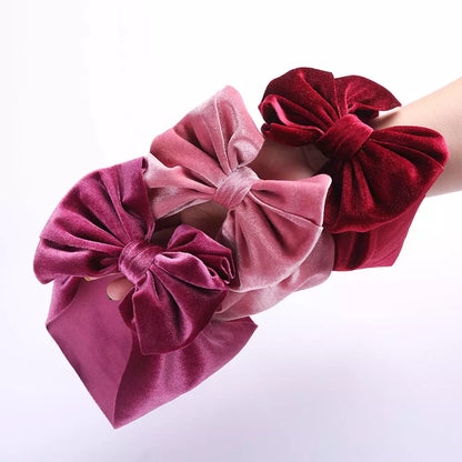 Baby girl's soft pink velvet bow winter headband, perfect for newborns and toddlers