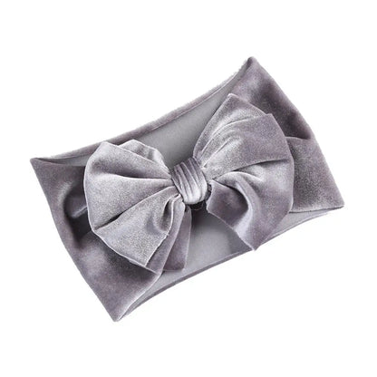 Little girl showing off a burgundy velvet bow baby headband, perfect winter accessory