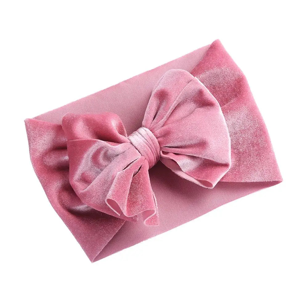 Close-up of the delicate velvet bow on a baby girl's winter headband
