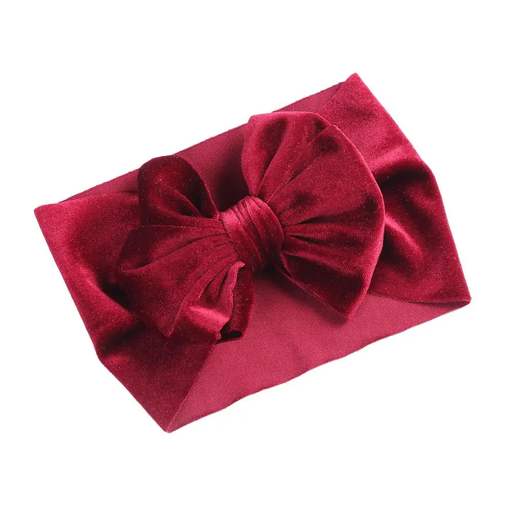 Infant photoshoot featuring a charming plum velvet bow baby headband