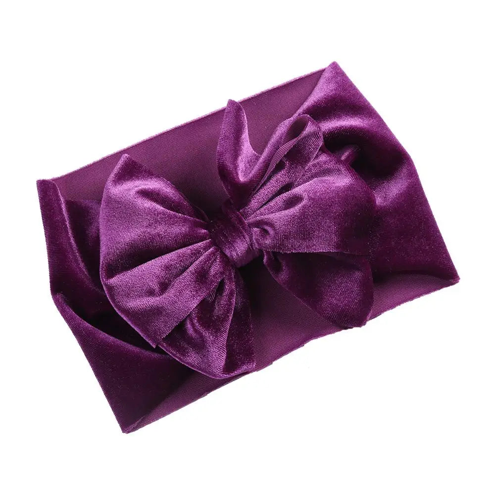 Cute baby wearing a forest green velvet bow headband, cozy winter accessory
