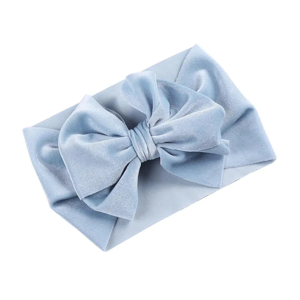 Stylish baby girl with a dusty rose velvet bow winter headband, perfect for cold weather