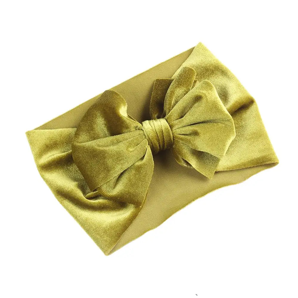 Newborn wearing a delicate silver grey velvet bow winter headband, elegant accessory