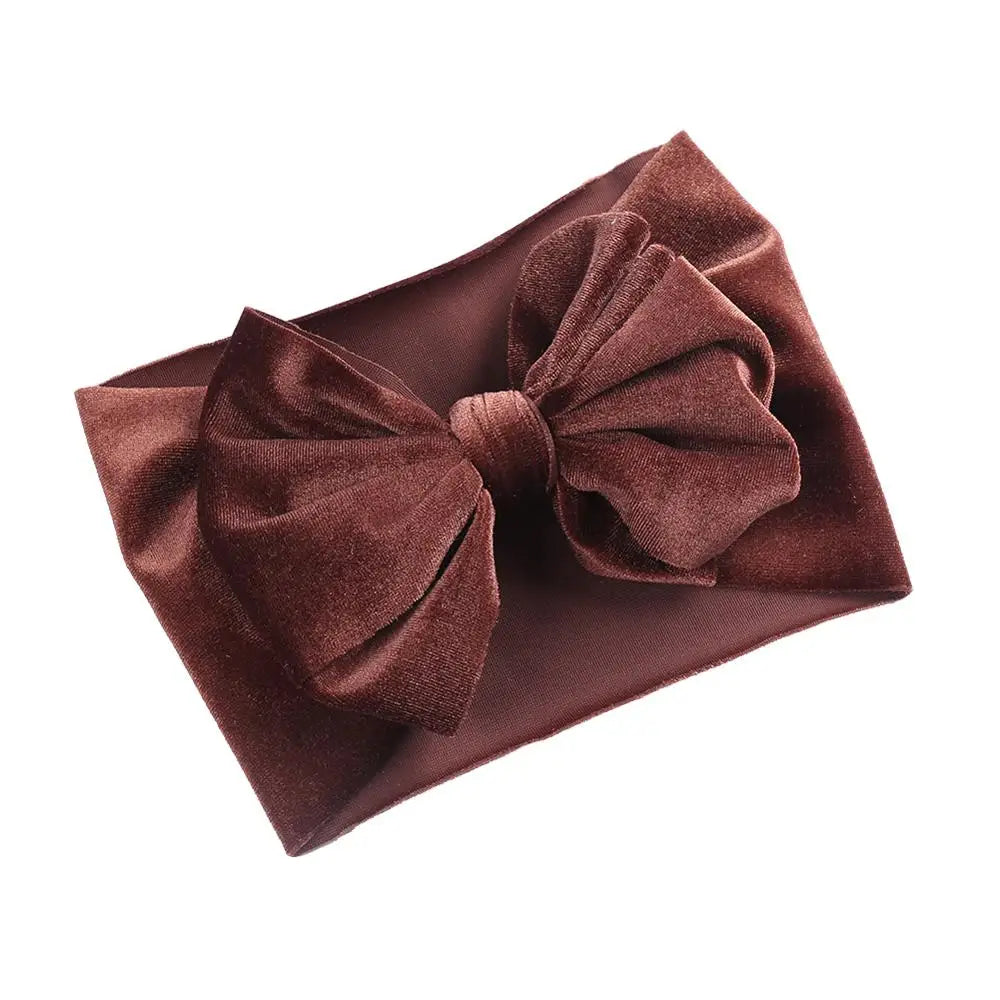 Baby girl's velvet bow winter headband in a deep emerald green, comfortable fit