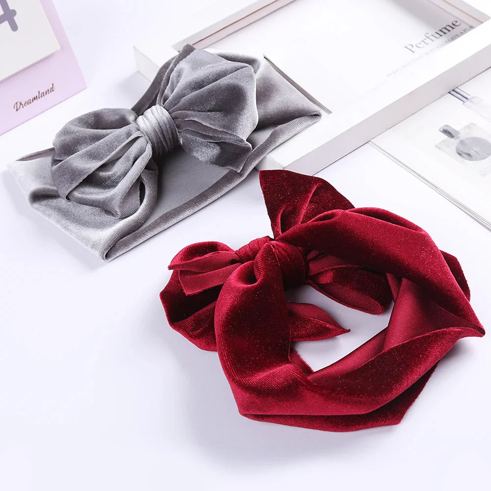 Velvet bow baby headband in a cheerful coral, ideal winter accessory for active girls