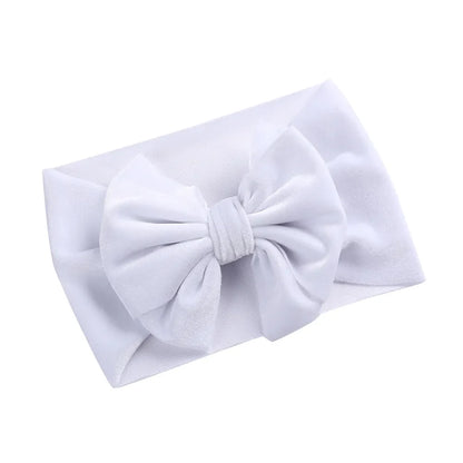 Baby girl with a shimmering gold velvet bow winter headband, festive and soft