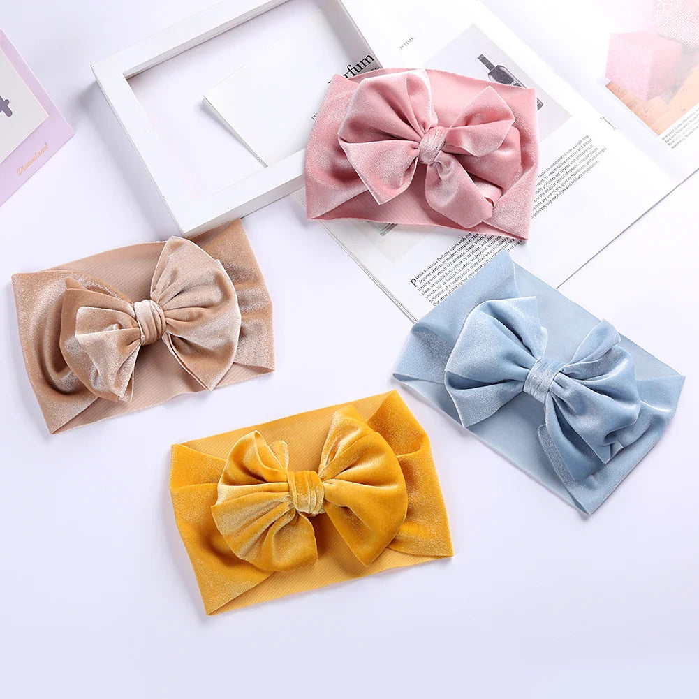 Adorable baby girl styling a purple velvet bow winter headband, newborn fashion