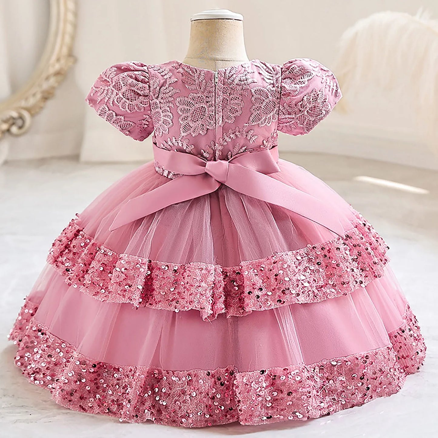 Pink glitter sequin and layers of tulle define this baby girl's festive special occasion dress
