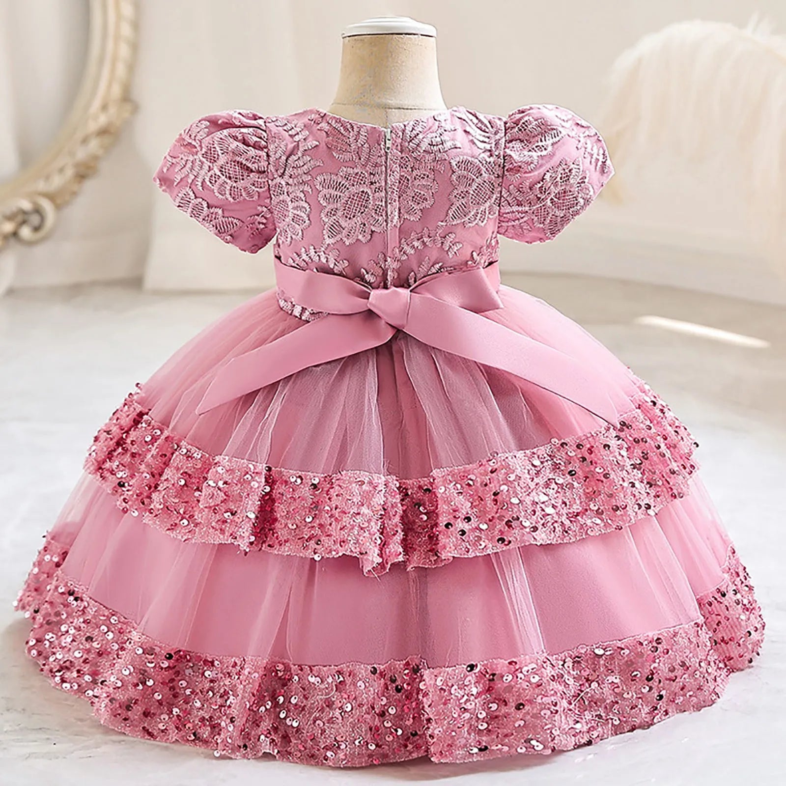 Pink glitter sequin and layers of tulle define this baby girl's festive special occasion dress