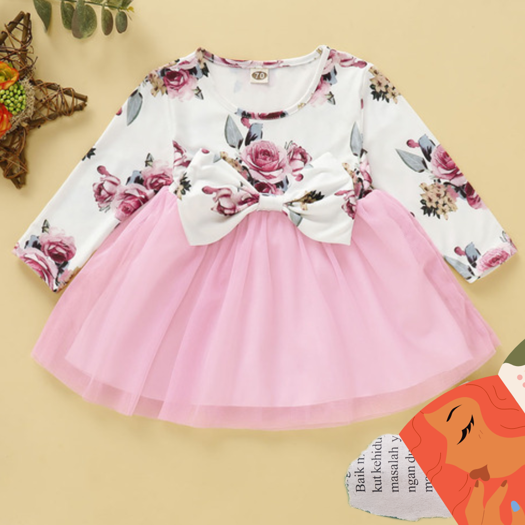 Close-up of a baby girl's long sleeve dress featuring an intricate rose print and bow detail.