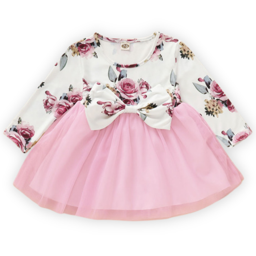 Full shot of a toddler girl's cotton blend vintage rose dress with long sleeves and bow accent.