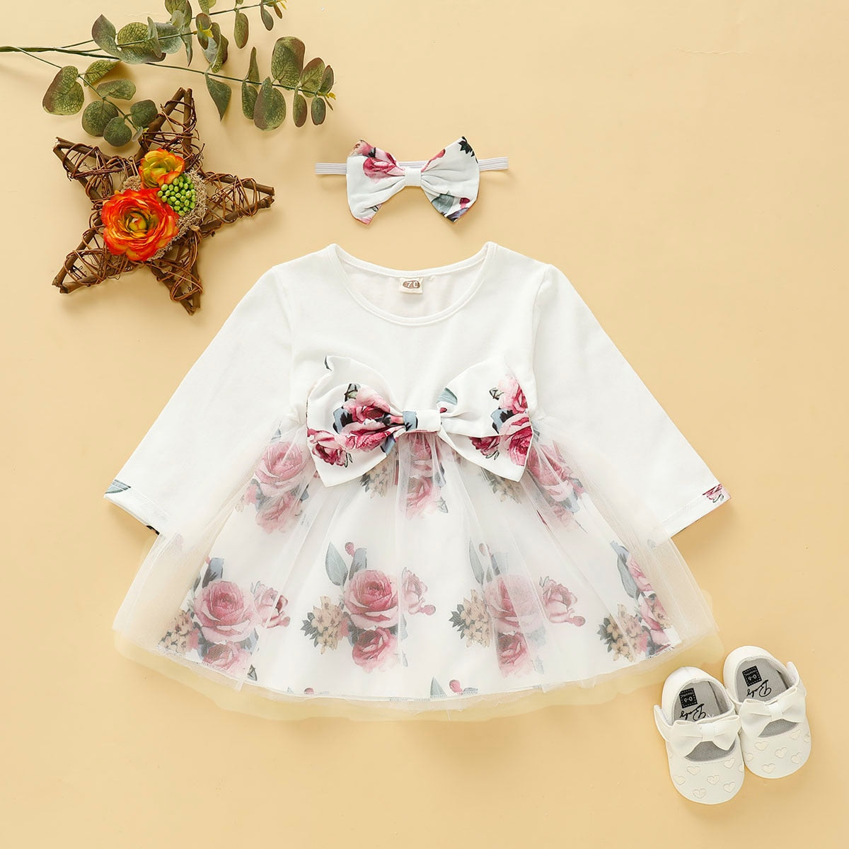Adorable baby girl in a long sleeve vintage rose print dress, perfect for spring/summer.