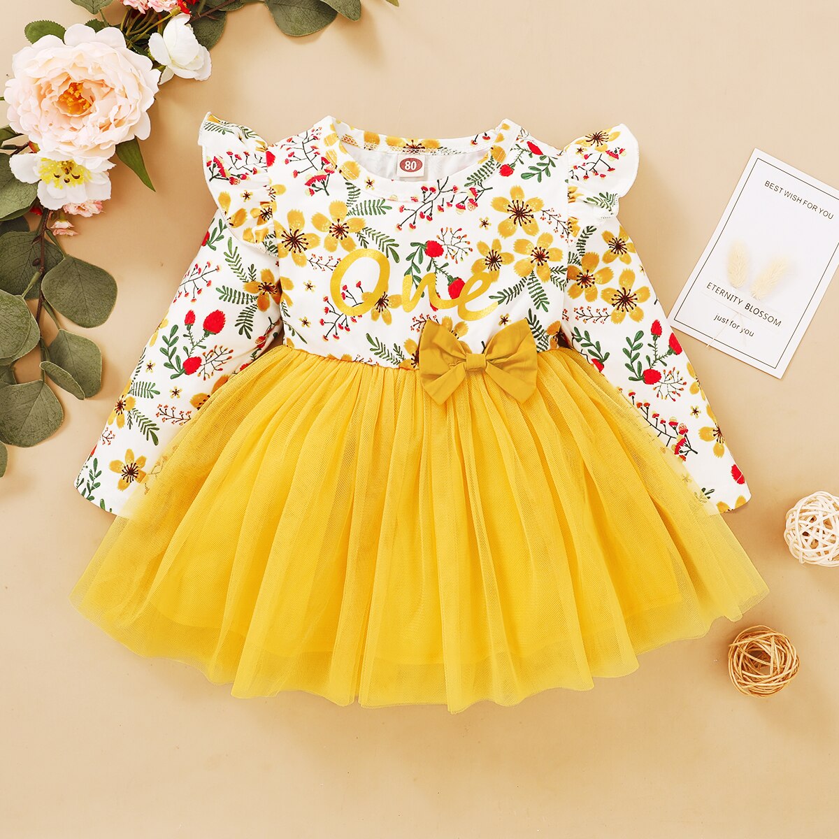 Flowy baby girl's dress with vintage rose pattern and a cute bow, ideal for girly fashion.