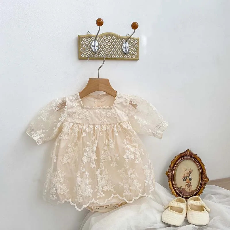 Short-sleeved baby girl's summer bodysuit in white cotton with elegant lace and embroidery.