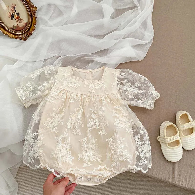 Baby girl's cotton bodysuit with charming floral embroidery and delicate lace accents for summer.