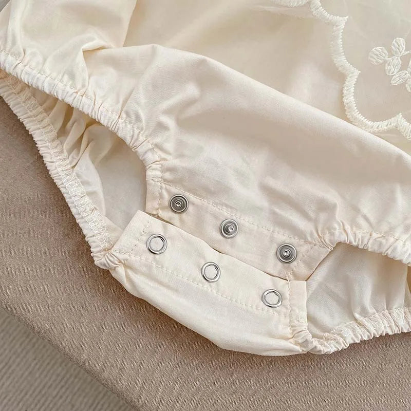 White cotton newborn bodysuit with exquisite lace and embroidery, perfect for a summer baby girl.