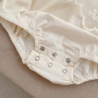 White cotton newborn bodysuit with exquisite lace and embroidery, perfect for a summer baby girl.