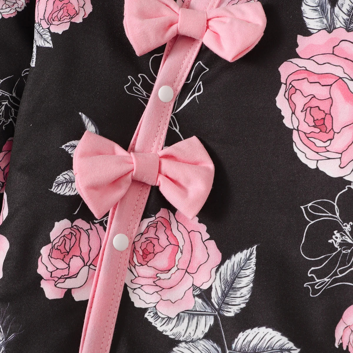 Side view of a baby girl's floral romper showing the comfortable fit and charming bowknot accents.