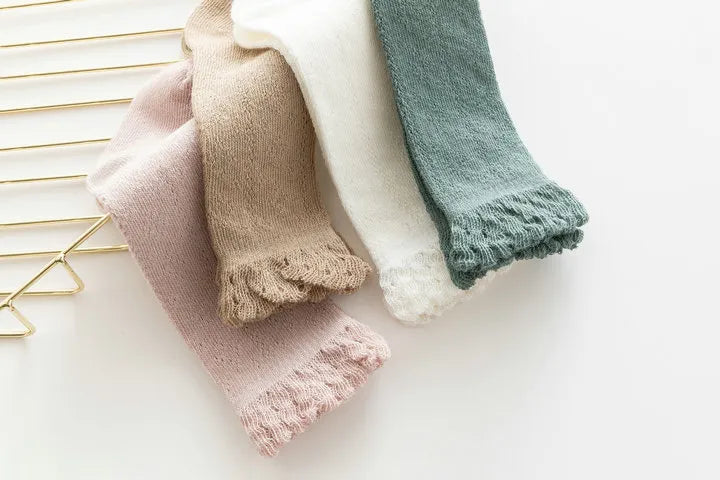 Hollow knit knee-high socks in pastel green for baby girls, ideal for spring attire.