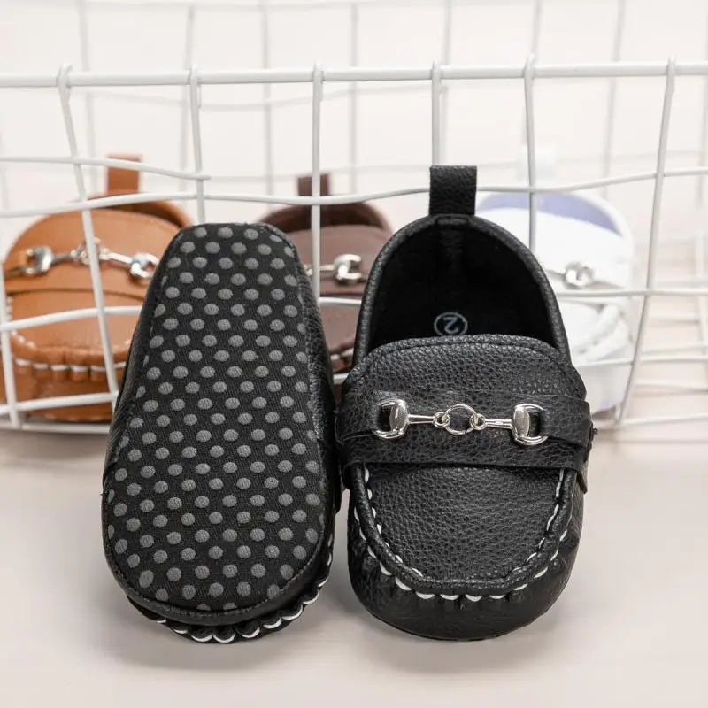Close-up of pink leather baby shoes with non-slip soft sole and decorative details