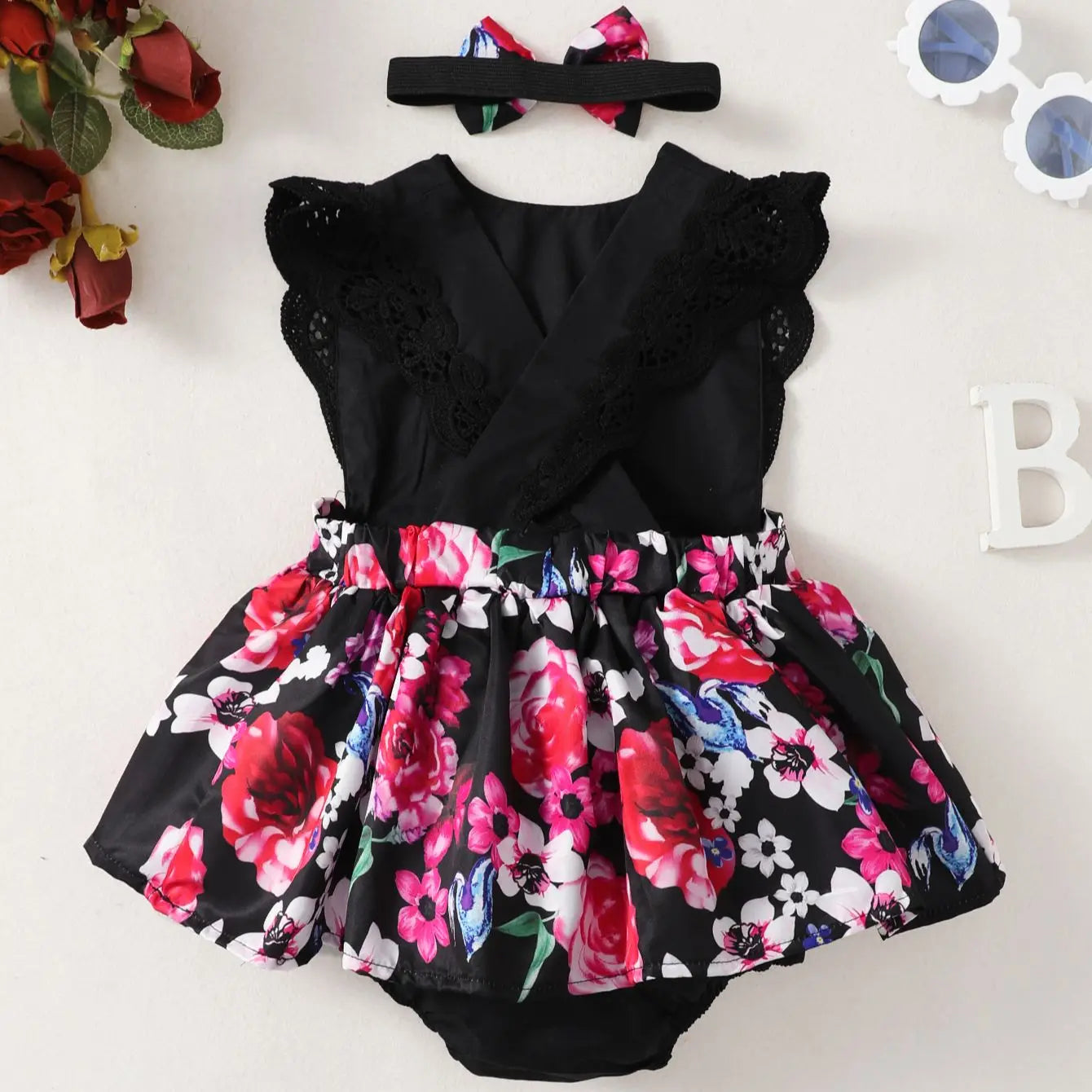 Close-up of lace flower print on a baby girl's summer sleeveless dress, soft polyester fabric