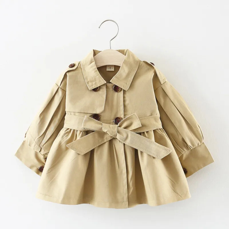 Baby girl wearing a chic pink cotton trench coat, perfect for spring outerwear.