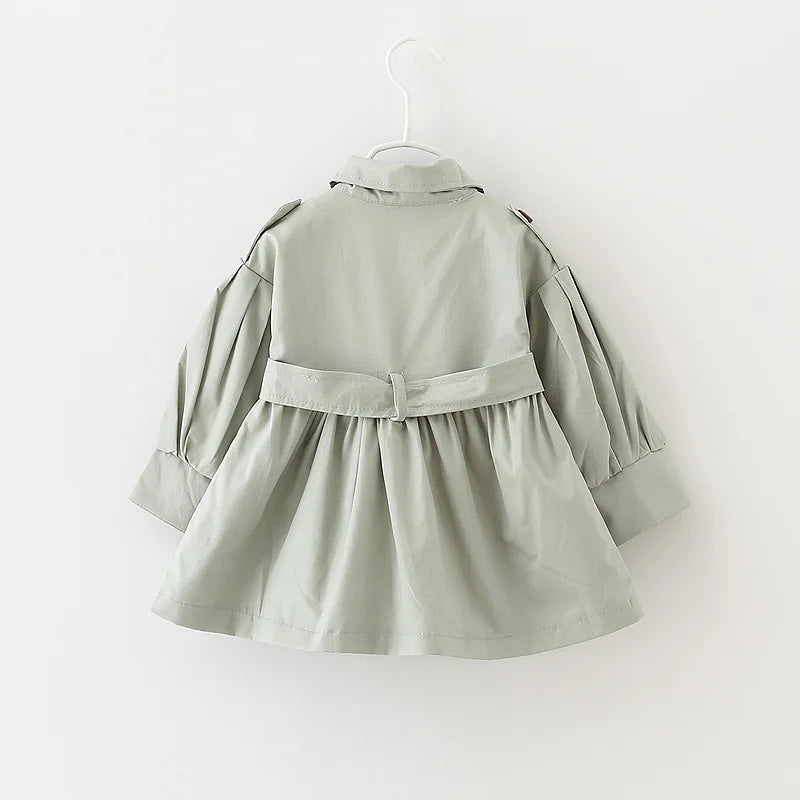 Happy toddler in a broadcloth cotton trench coat, enjoying the outdoors, kids fashion.