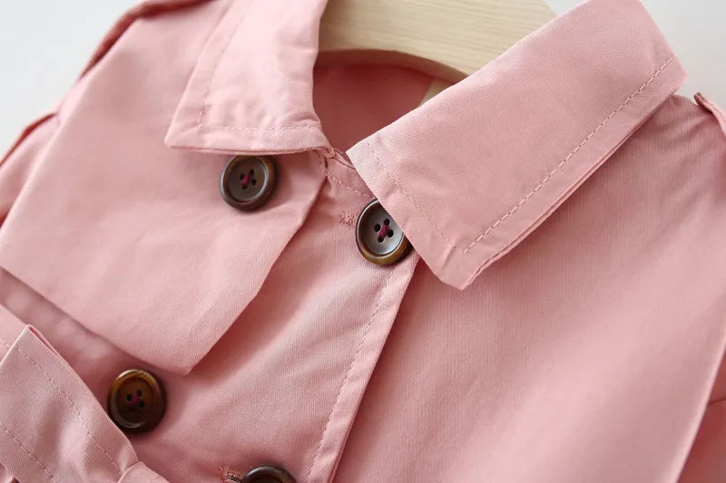 Close-up of the broadcloth fabric texture of a girls' cotton trench coat, quality outerwear.