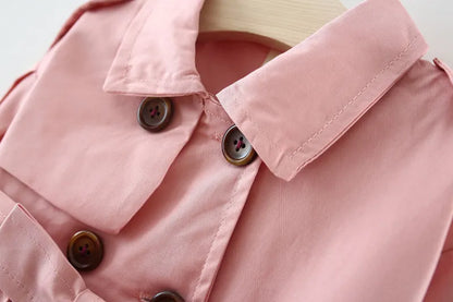 Close-up of the broadcloth fabric texture of a girls' cotton trench coat, quality outerwear.
