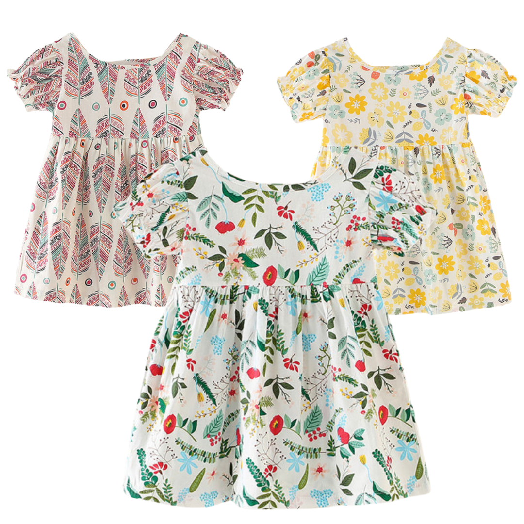 Baby girl wearing a nature pattern puff sleeve sundress, front view, perfect for summer.