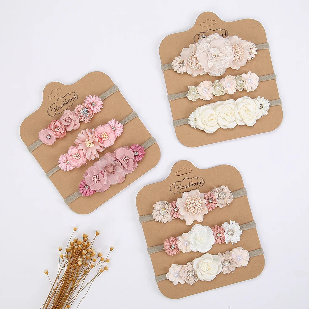 Baby girl wearing a pink artificial flower headband with rhinestones, soft nylon band, ideal for newborns.