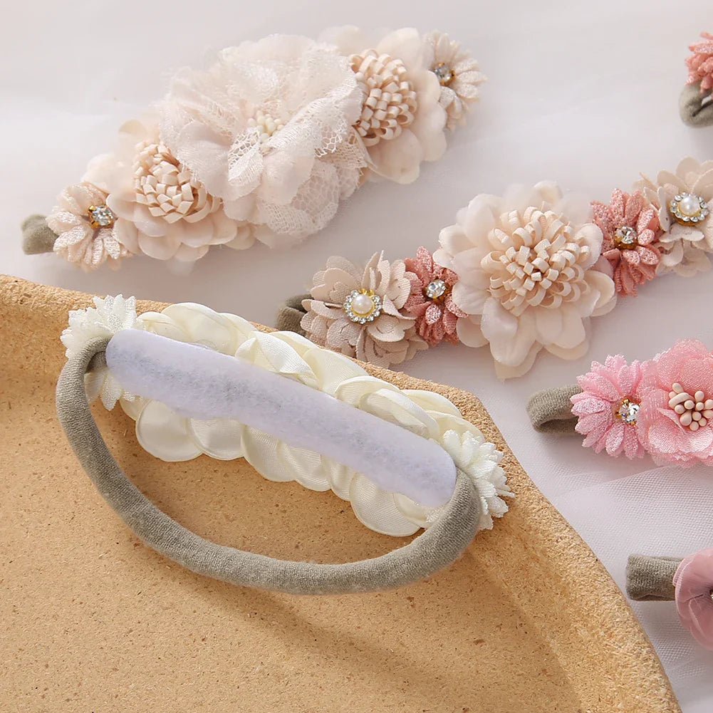 Toddler girl smiling, wearing a beautiful pink floral headband with rhinestone accents, comfortable nylon band.