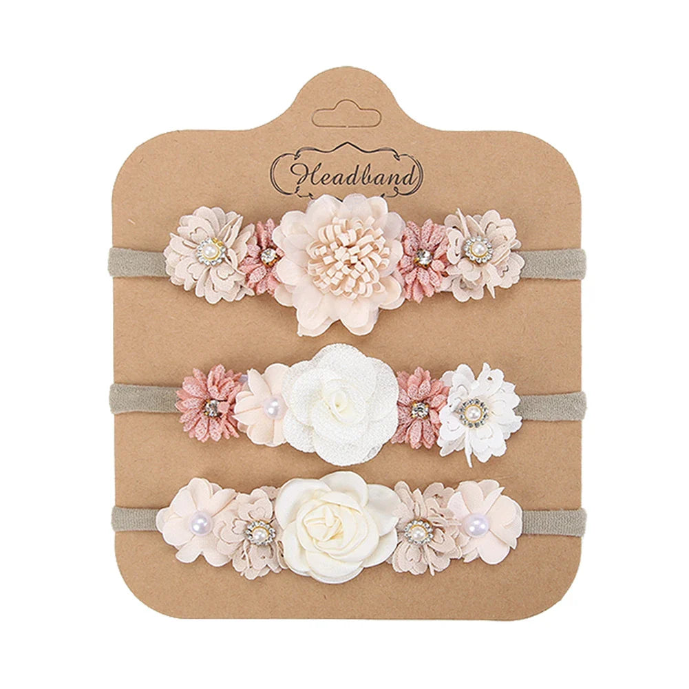 Close-up of the intricate detail of an artificial flower baby headband with clustered rhinestones and soft band.