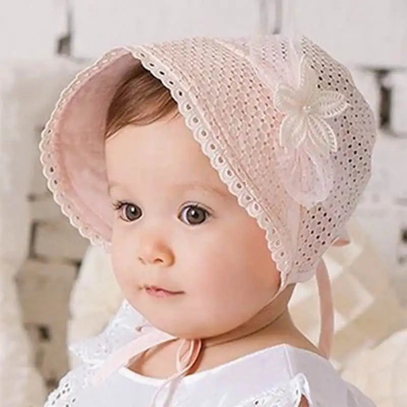Baby girl wearing a white lace flower sun hat, perfect for summer sun protection.