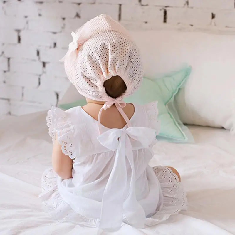 Cute toddler girl modeling a white lace flower sun hat, ideal for beach or park days.