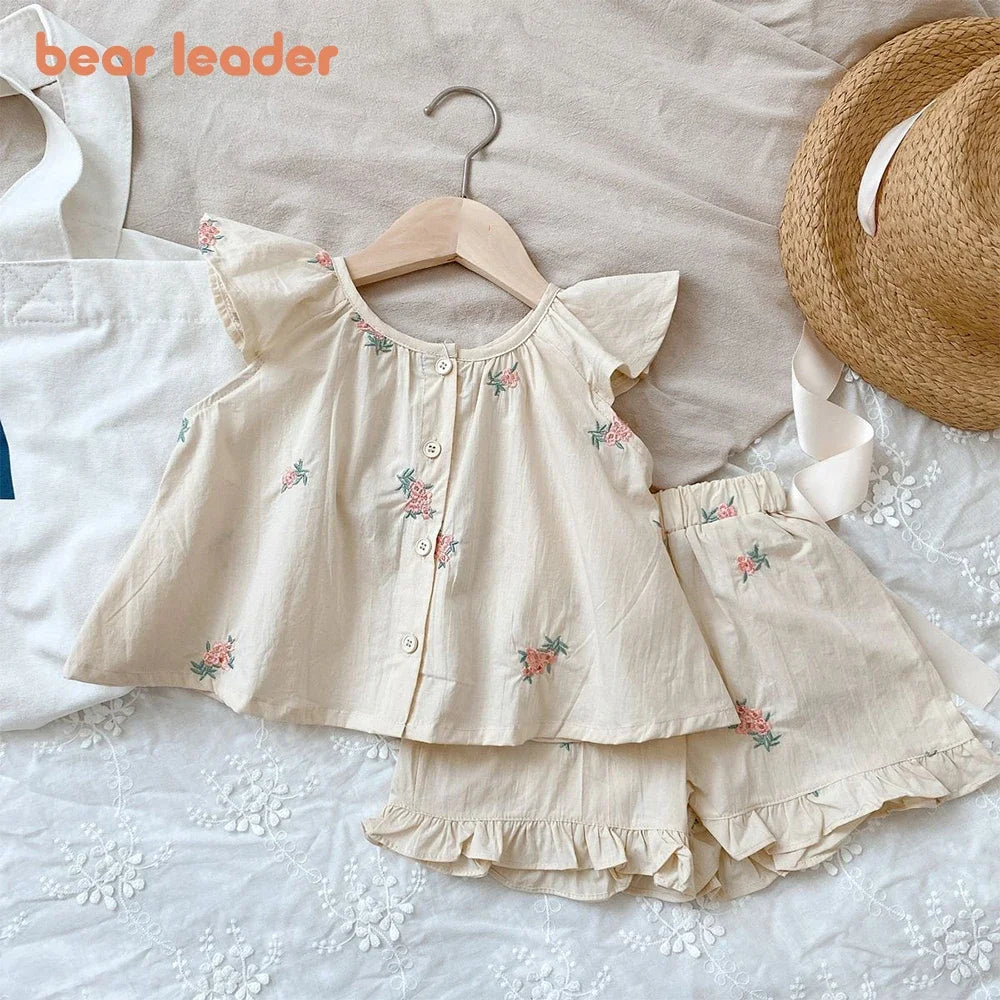 Close-up of girls' floral print flying sleeve top featuring vibrant flower patterns and ruffled sleeves.