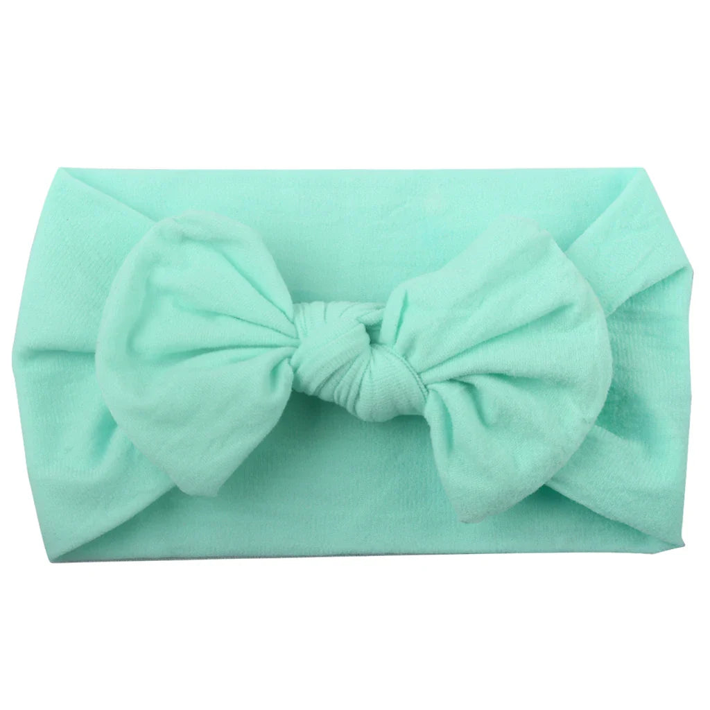 Baby girl sleeping peacefully with a delicate pink bowknot headband, photo prop.