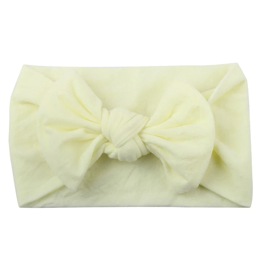 Baby girl playing, showcasing a comfortable and elastic polka dot bowknot headband.