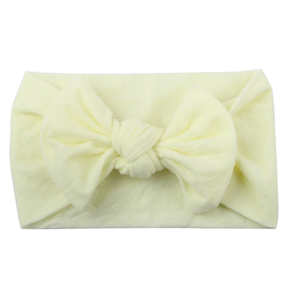 Baby girl playing, showcasing a comfortable and elastic polka dot bowknot headband.