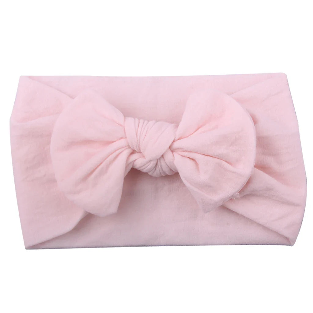 Closeup of the soft elastic material of a baby girl's bowknot headband.