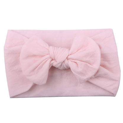 Closeup of the soft elastic material of a baby girl's bowknot headband.