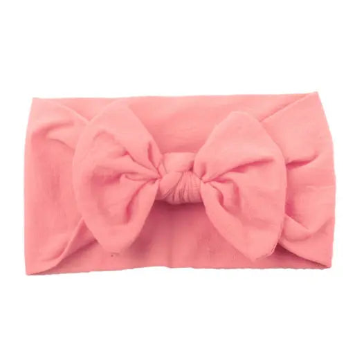 Infant modeling a purple bowknot headband, soft, elastic, and stylish baby accessory.