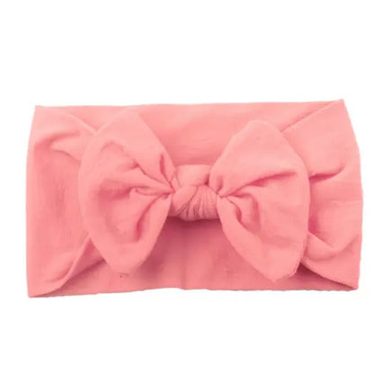 Infant modeling a purple bowknot headband, soft, elastic, and stylish baby accessory.