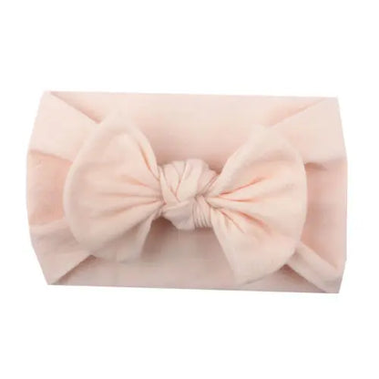 Close up of fine details on a baby bowknot headband, showing soft elastic fabric.