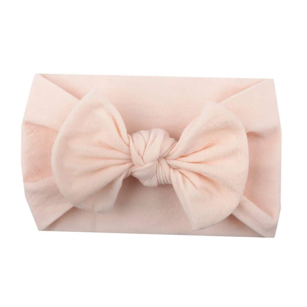 Baby girl with an adorable red bowknot headband, soft and comfortable headwear.