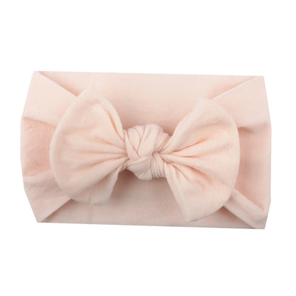 Baby girl with an adorable red bowknot headband, soft and comfortable headwear.