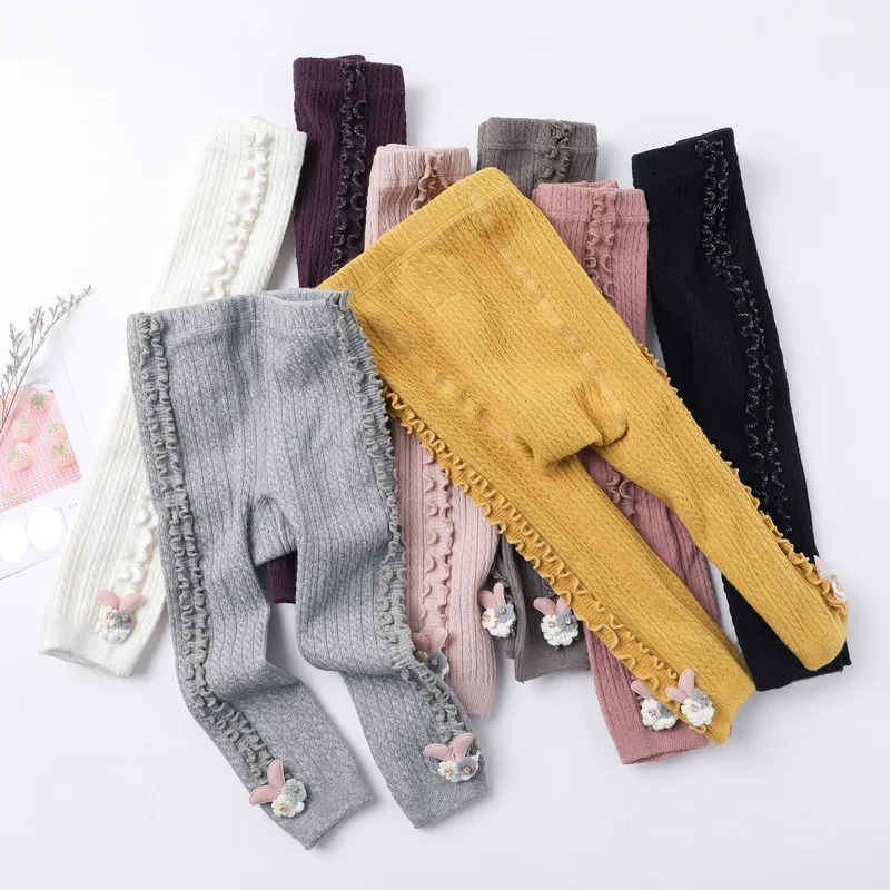 Baby girl wearing pink ribbed cotton tights, perfect for cozy infant legwear and warmth.